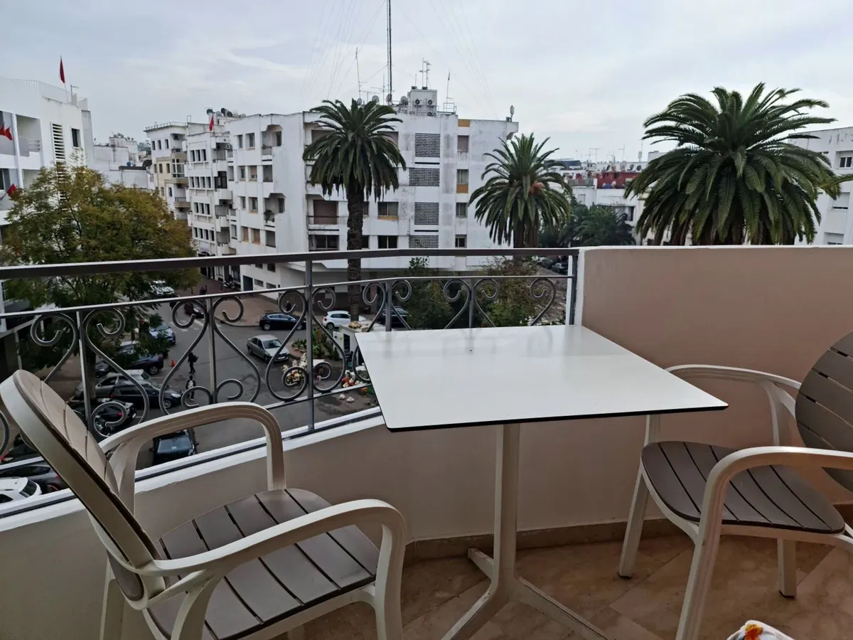 Balcon avec vue sur une rangée de palmiers et les immeubles voisins