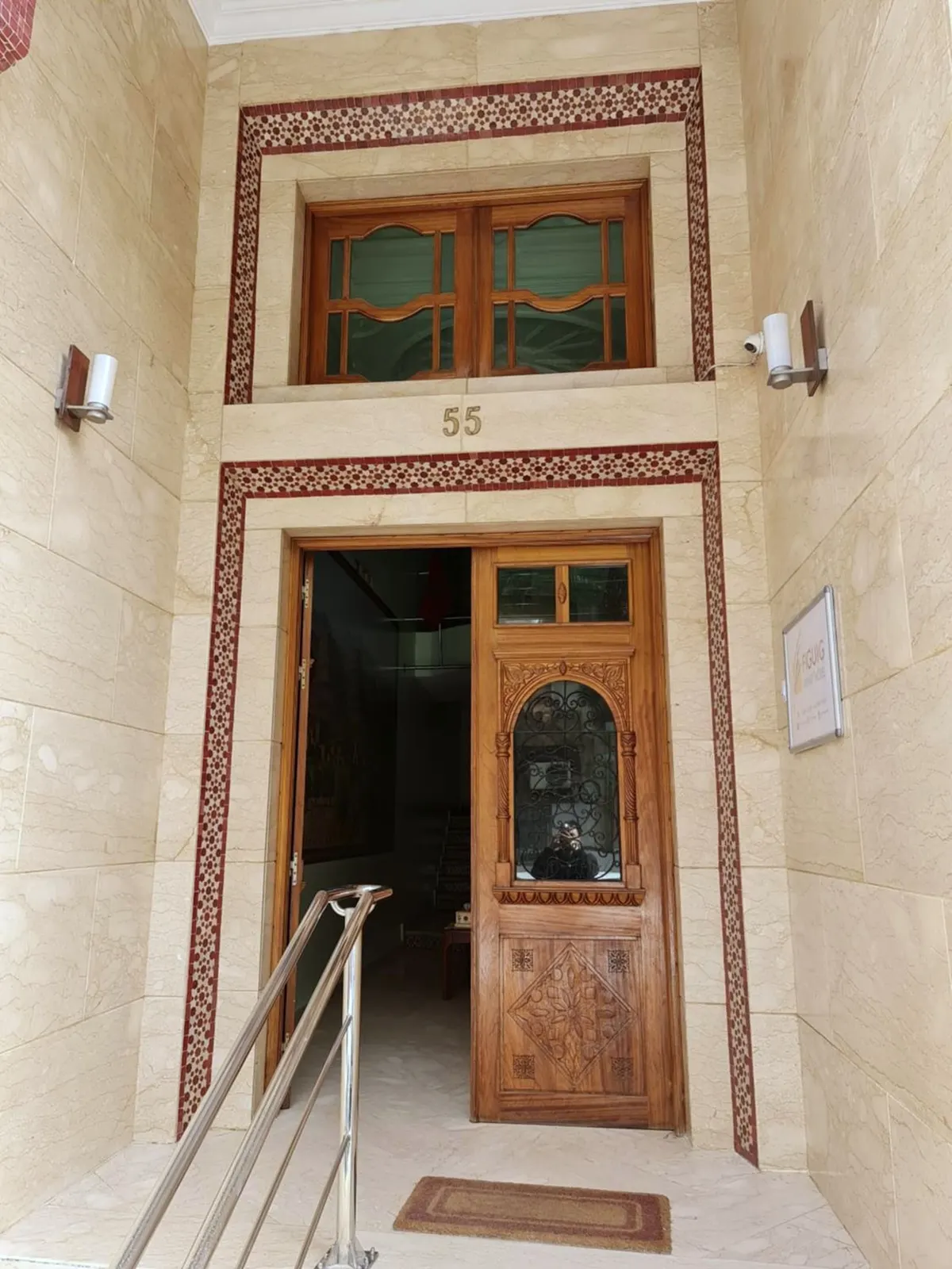 Porte d'entrée en bois sculpté, numéro 55 au-dessus, encadrement de pierre