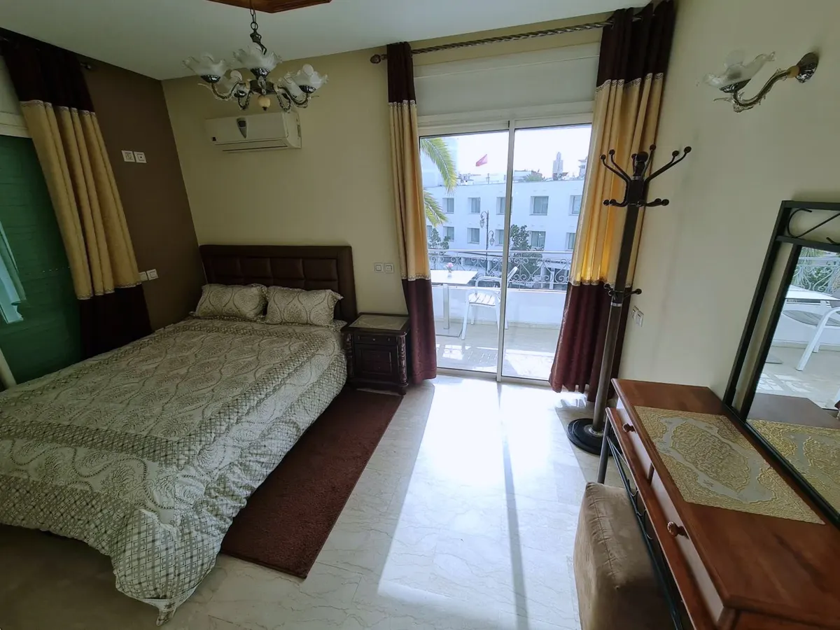 Chambre avec lit double et porte-fenêtre ouvrant sur le balcon